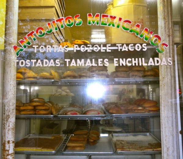 Little Mexico panaderia The shop window of a Mexican panaderia in New York, in the manhattan district - with trays of tortas, tacos, tostadas, tamales and enchiladas