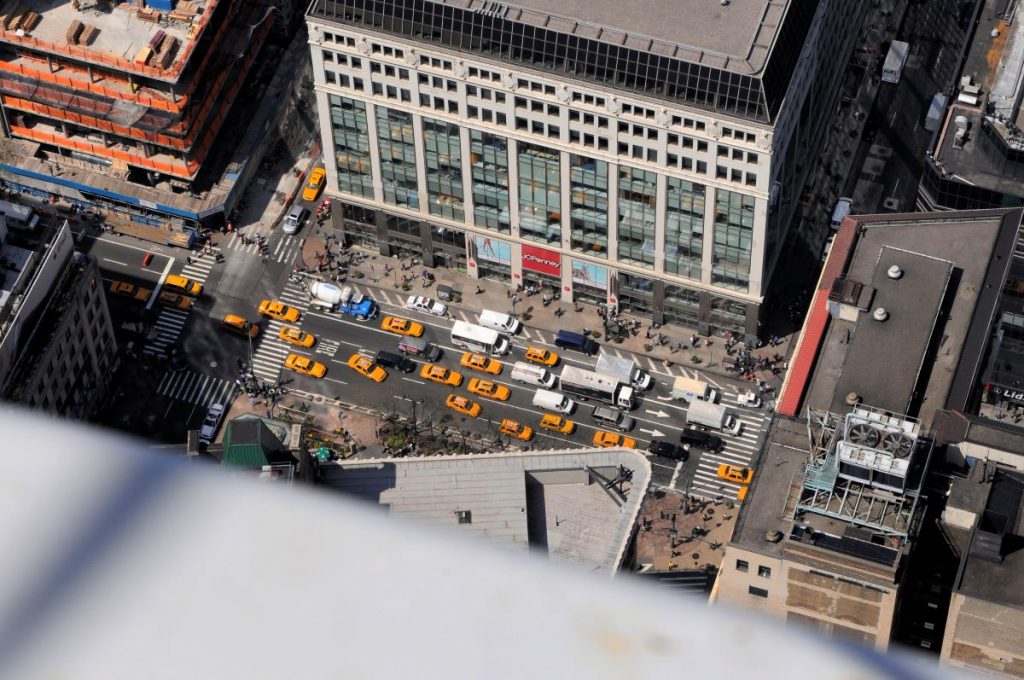 aerial view from the top of the Empire State building. Below taxis and vans zoom by