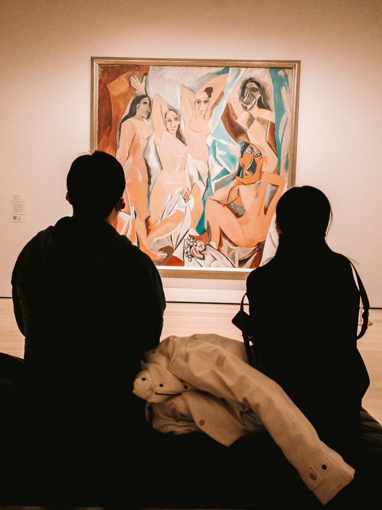 People sitting on a bench admiring artwork at MoMA is New York.