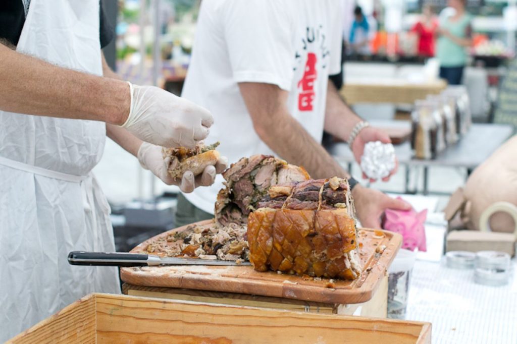 cooks making porshetta sandwiches at Smorgasburg market.