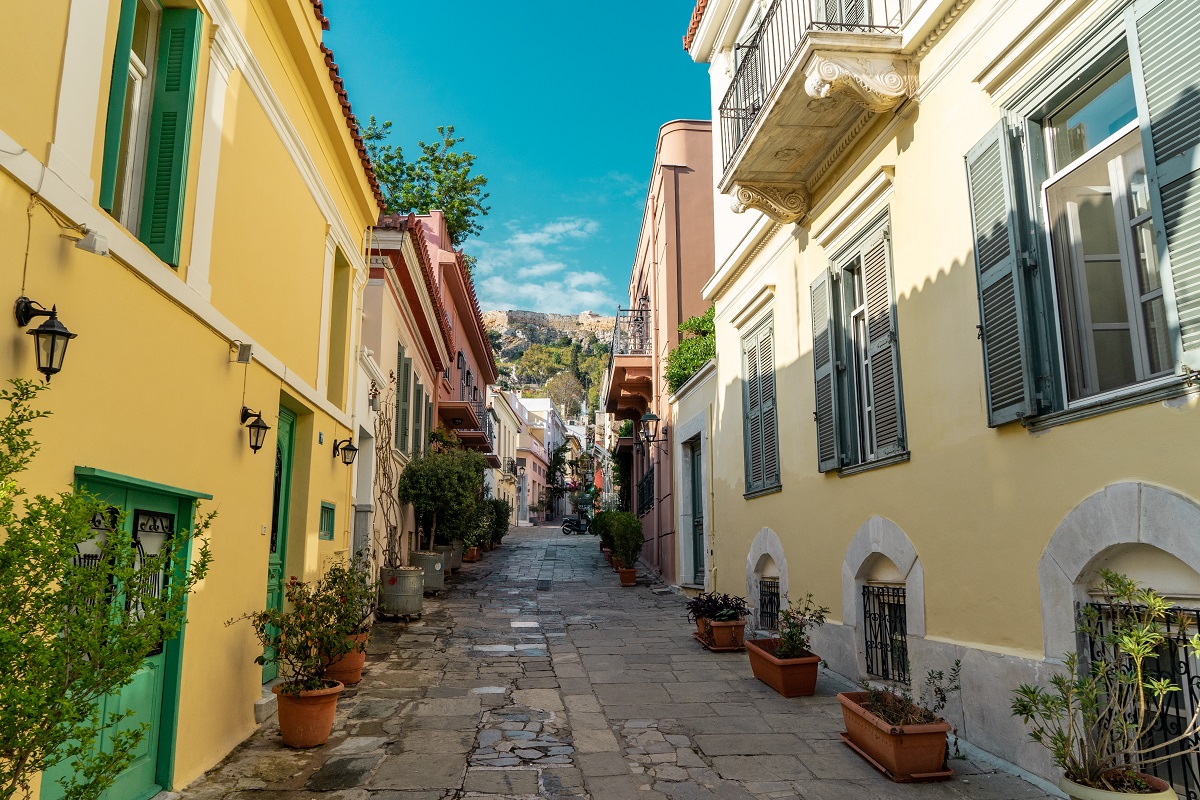 Quiet, colorful street with plants in Plaka, Athens.