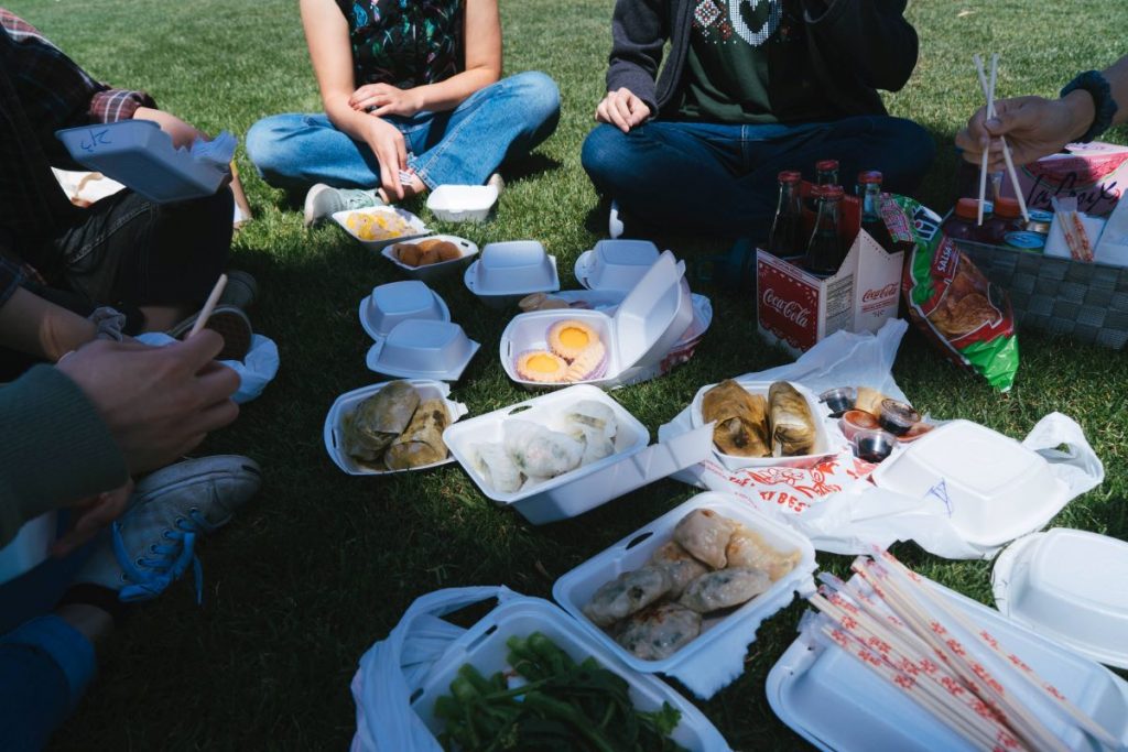 People gather on a sunny day in a San Francisco park to eat dim sum.