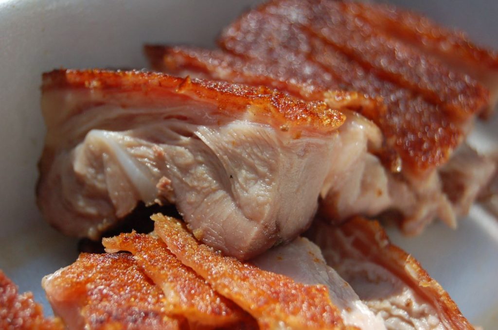 A close up of pieces of freshly carved roast suckling pig