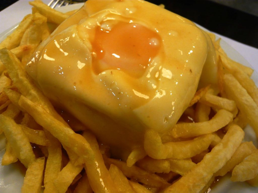 The famouse Portuguese Francesinha sandwich - with egg, cheese, and fried potatoes