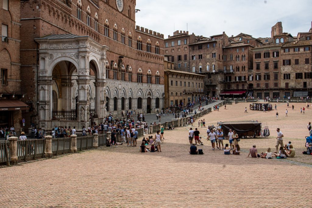 People relaxing in the Piazza del Campo in Siena while on a day trip from Florence.