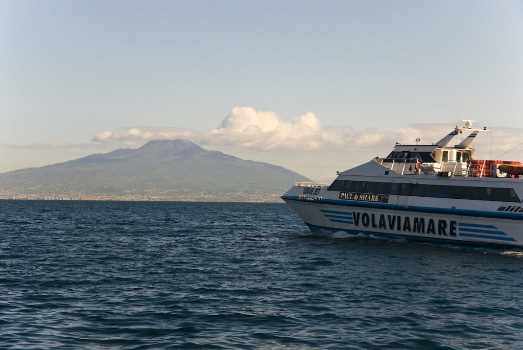 Taking the ferry to Sorrento, Italy. A smaller ferry boat on the sea with mountains in the background