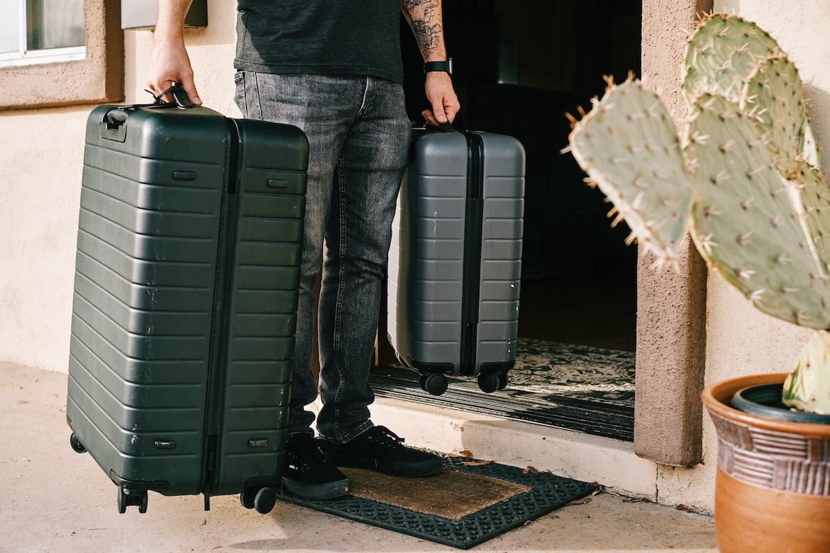 Person carrying two heavy suitcases