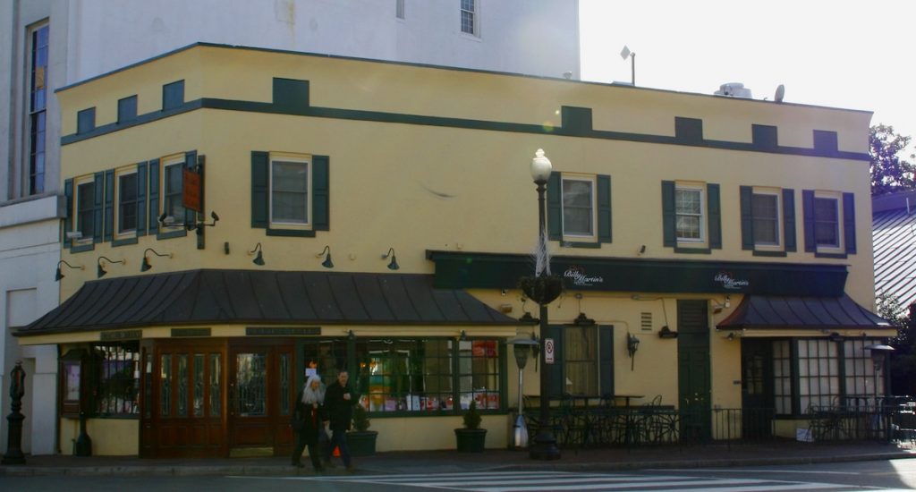 people crossing the street in front of a restaurant, painted with lemon colour walls and dark canopies and window shutters. This is Martin´s tavern, one of the historic restaurants in DC