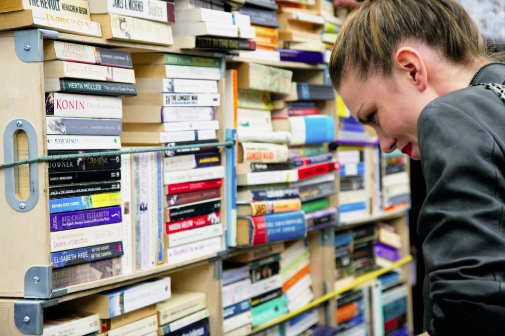 Woman searching for rare books at Greenwich market in London.