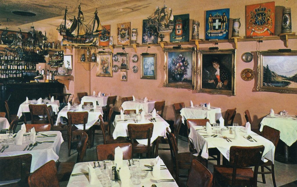 inside the german restaurant called Old Europe, in washington DC with many art pieces, paintings, ships, hanging on the walls above the tables