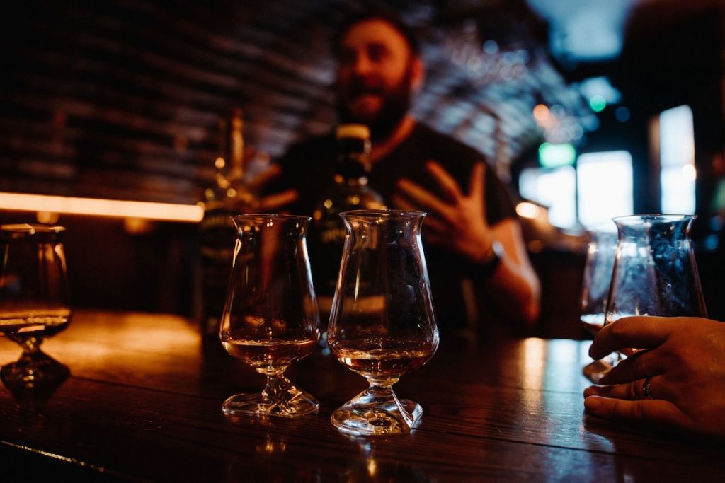 Pub owner speaking to people enjoying a whisky tasting in Edinburgh.