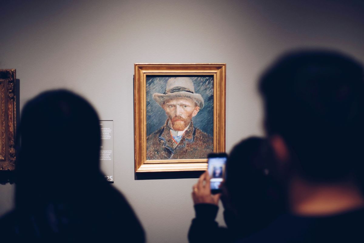 People at the Van Gogh museum Amsterdam, looking at a painting.