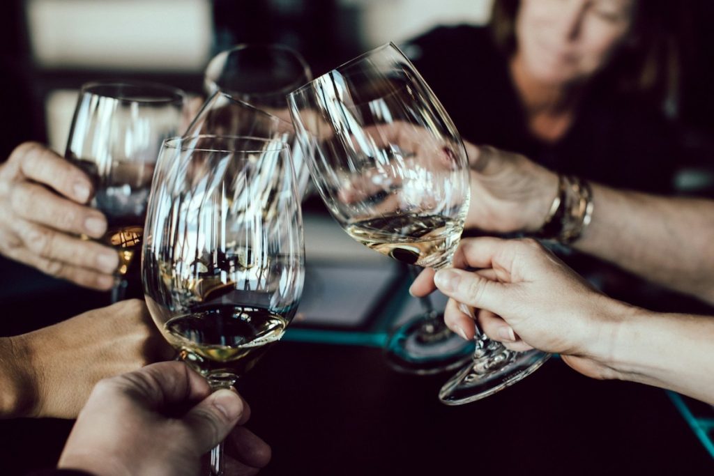 Five people raise wine glasses in a toast as they explore a Spanish city on a food tour