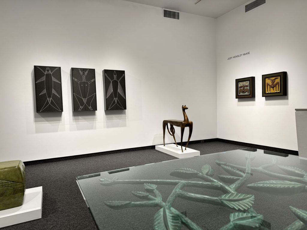 interior of a Boston art gallery and museum with tribal style artwork on white walls and a carved sculpture of an animal in wood