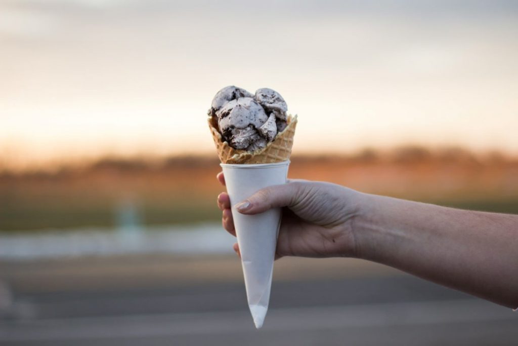 A person holding an ice cream cone with Stracciatella gelato.