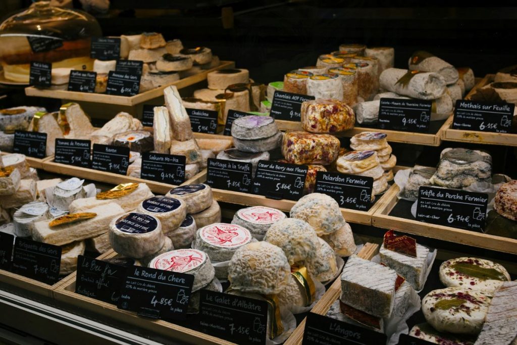 A cheese shop in France with rows of different cheeses to select as a gift from Paris.