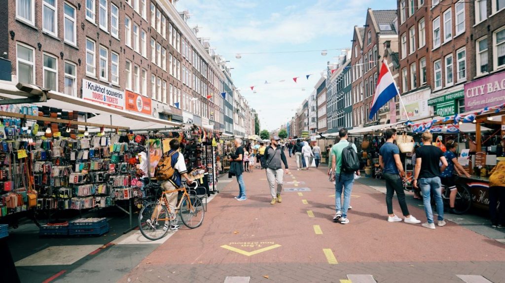 People walking around looking at shops at Albert Cuyp market in Amsterdam.