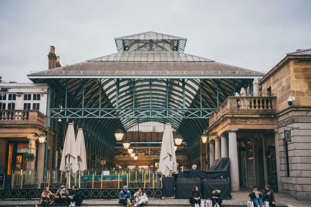 People hanging out outside of the Covent Garden market in London.