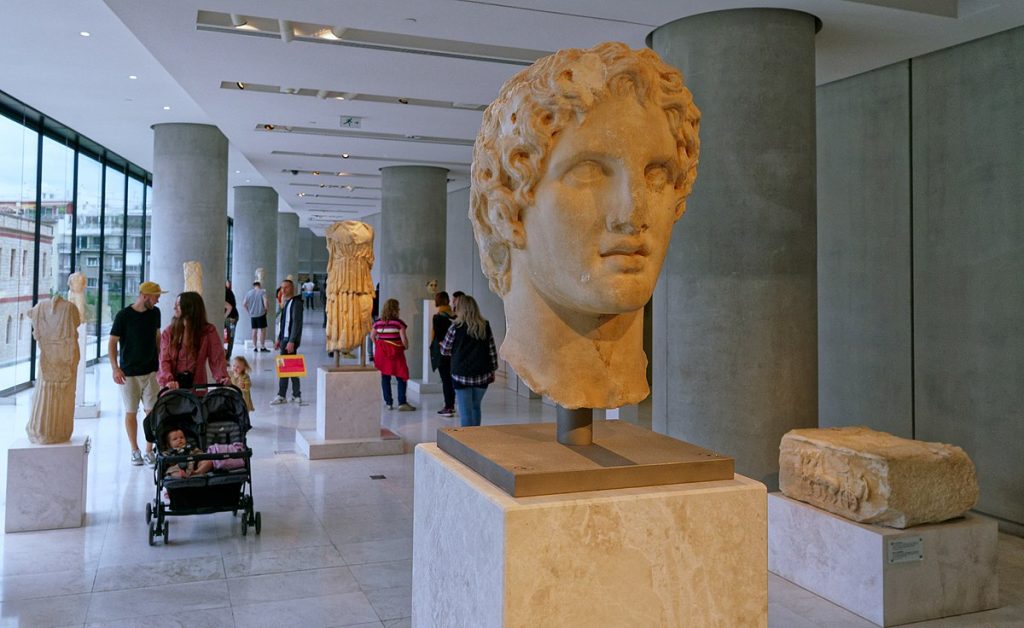 A woman walking around with children looking at art.