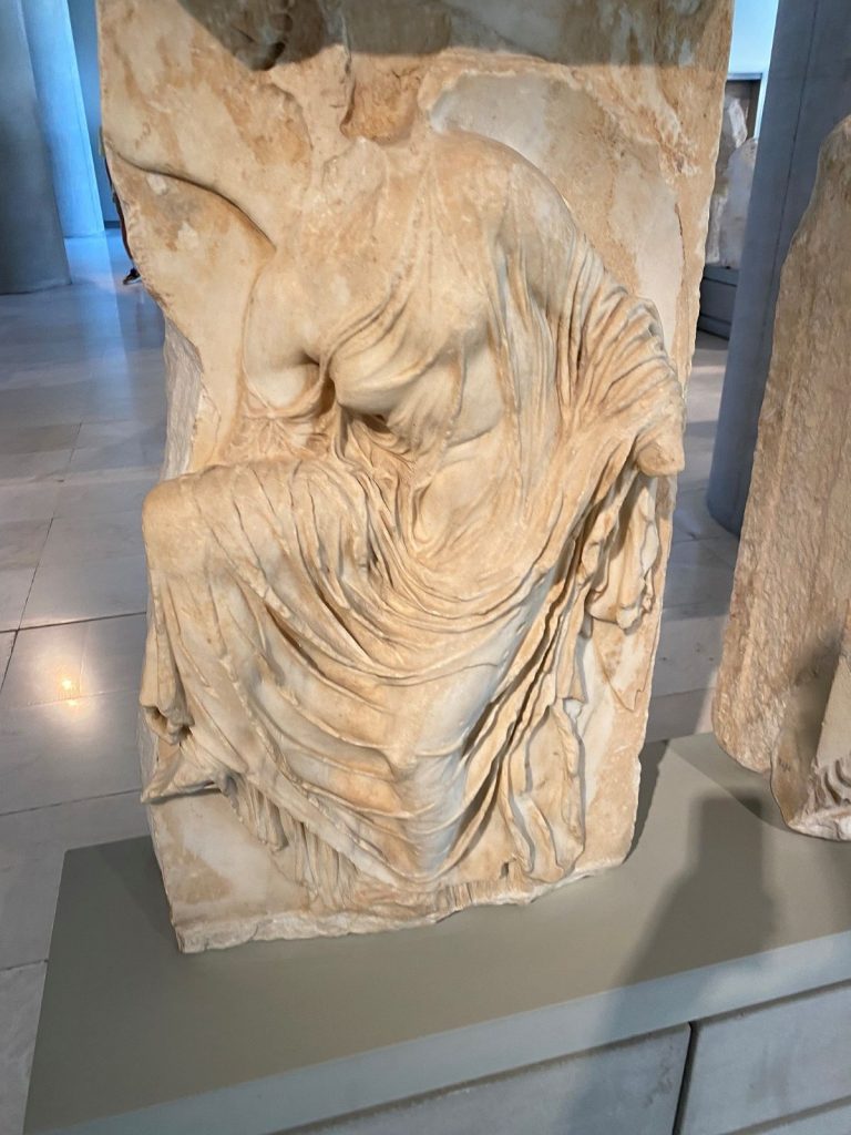 Nike adjusting her sandal at a museum.