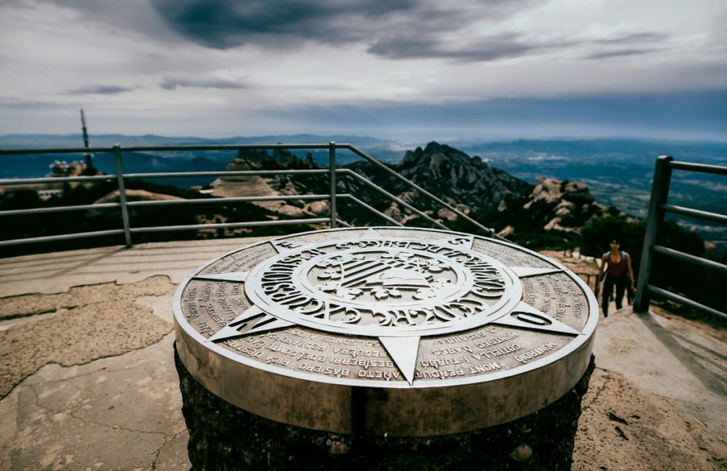 A compass at the top of a hiking trail in Montserrat, Spain.