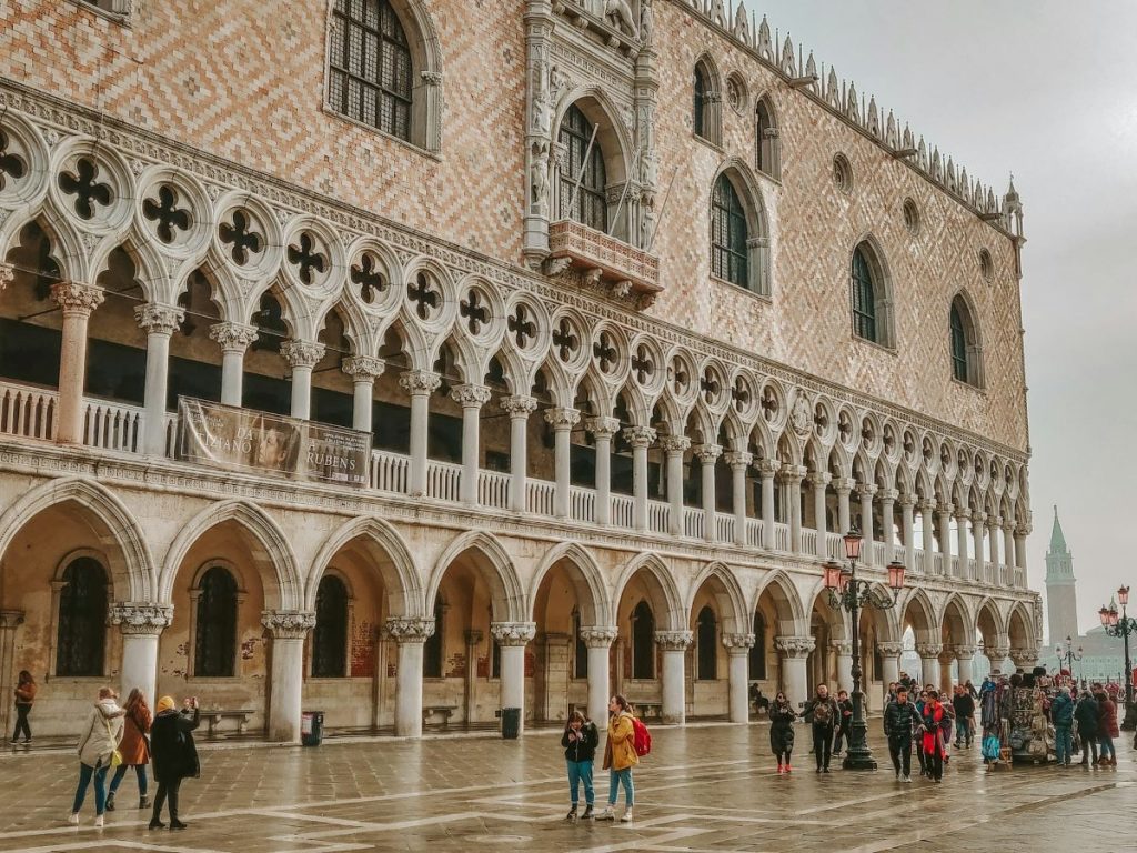 People standing outside of Doge's Palace taking photos and admiring the architecture