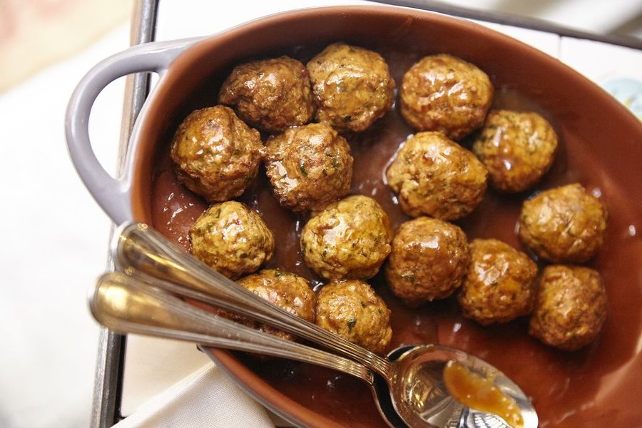A close up of a bowl of Milanese meatballs in sauce, a traditional food eaten by locals and tourists in Milan