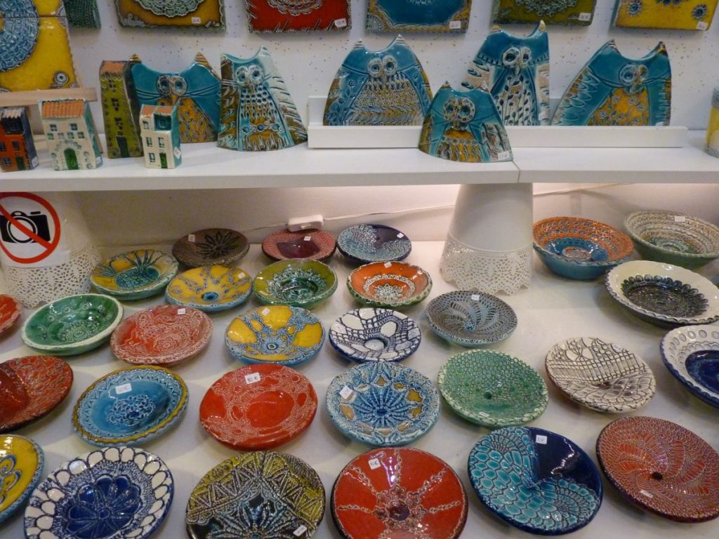 A large selection of brightly coloured ceramic plates and pots that you can find when shopping local in Lisbon