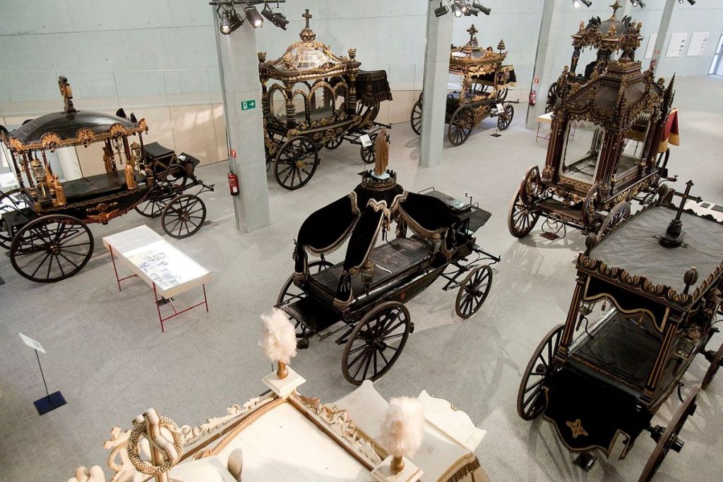 A show room with lots of funeral carriages at the Funeral Carriage Museum in Barcelona.
