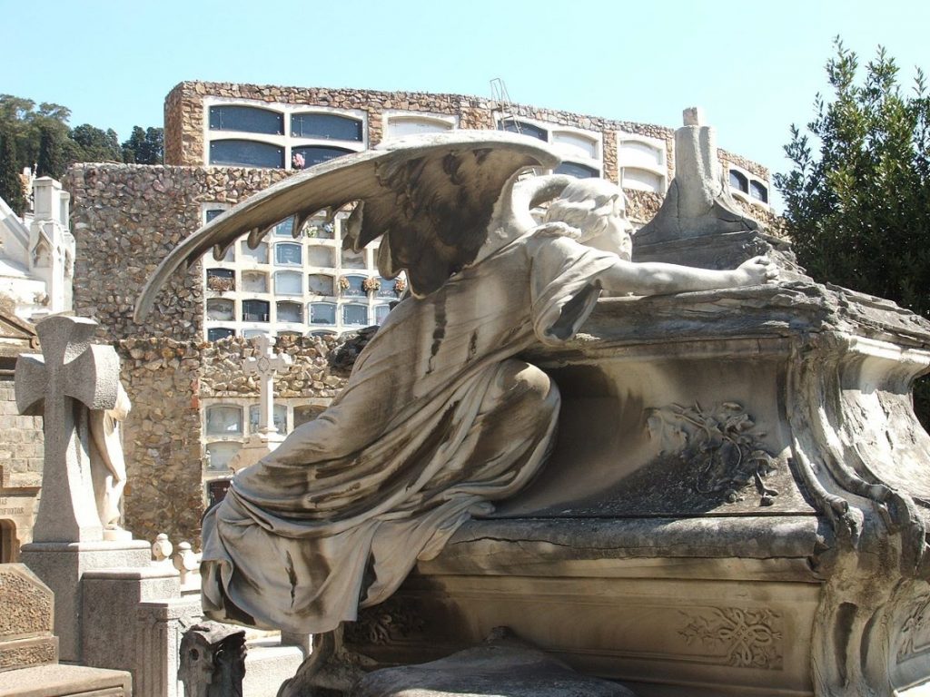 A neo-Gothic sculpture on top at a cemetery in Barcelona.