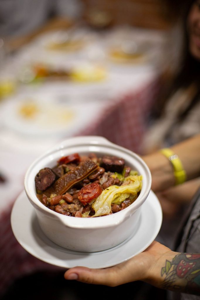 A person holding a steaming bowl of Portuguese stew.