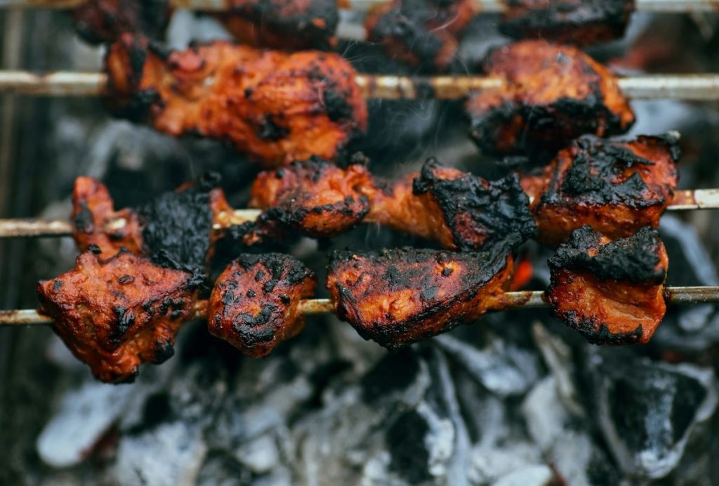 Meats on skewers being grilled in Astoria, Queens.