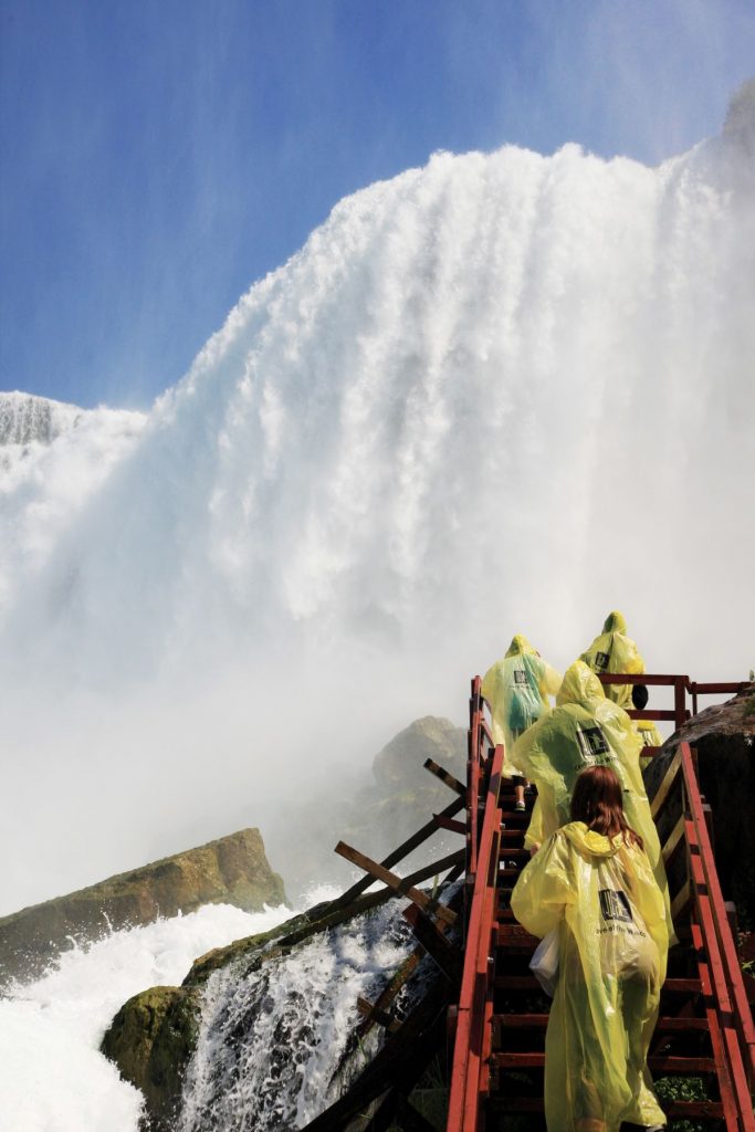 A group of people walking up steps to get views of waterfalls.