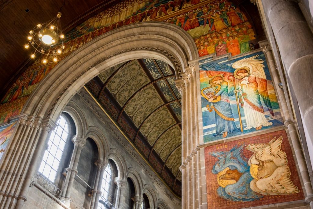 ornate archway with various art scenes on the wall