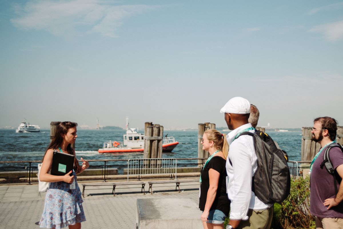 People standing at the waterfront at Battery Park while exploring New York neighborhoods.