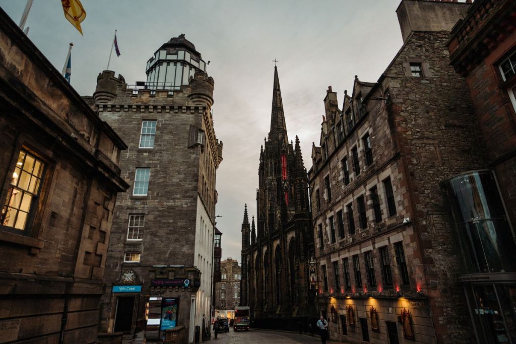 St Giles’ Cathedral rises at the end of Edinburgh’s Royal Mile, surrounded by historic buildings under a dramatic dusk sky.