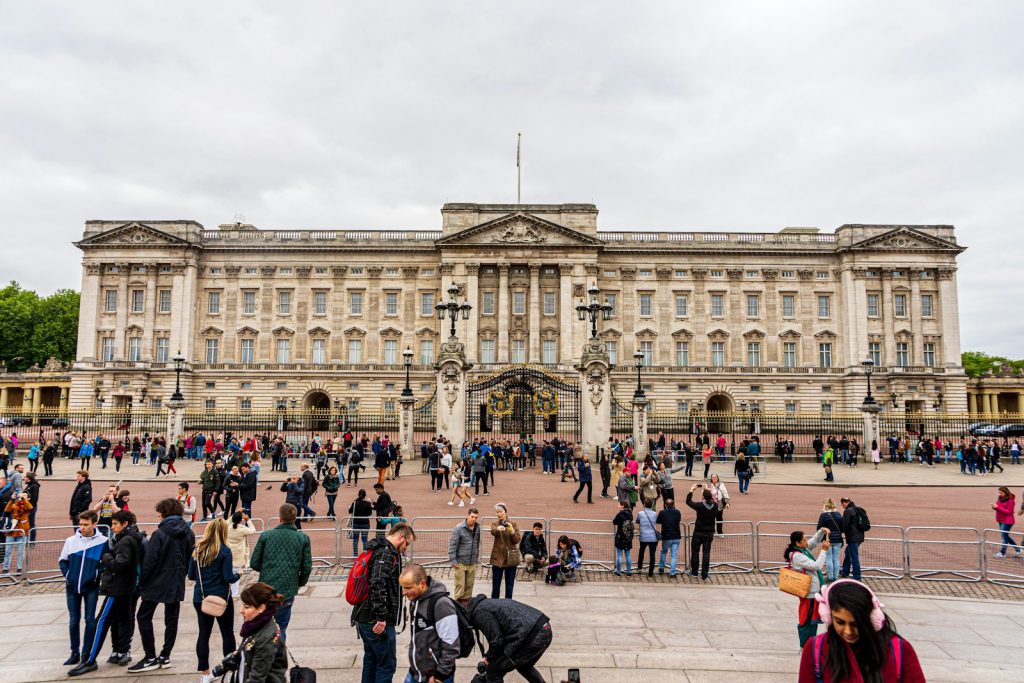 The front facade of Buckingham Palace, with people gathered ready to watch the changing of the guard or spot one of the Royal family of they are lucky. This is definitely one location on a London Travel Checklist